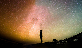 Silhouette of figure in front of planet