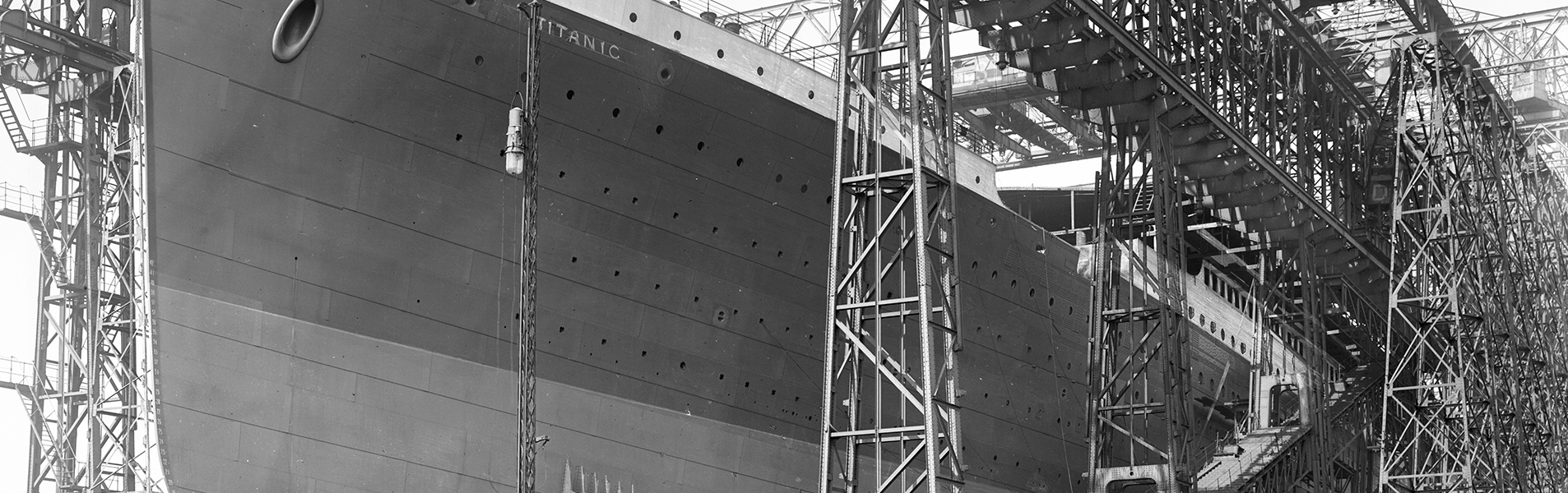 Black and white image of the titanic being built with scaffolding