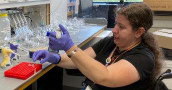 the cover of issue 29 of JES - Kelsey Byers, a scientist, wearing protective gloves uses a pipette in a laboratory setting